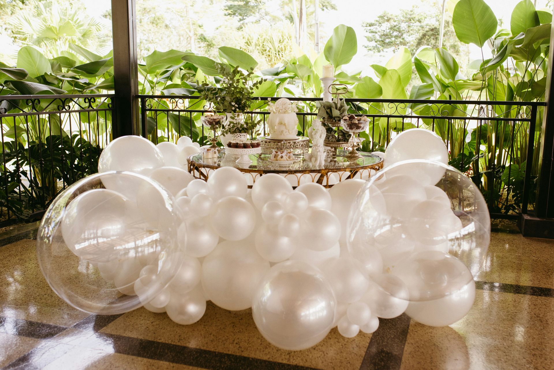 Elegant white and clear balloon display for a celebration.